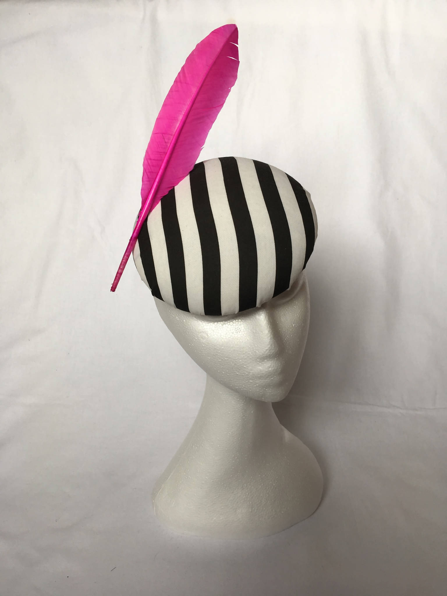 Black and white striped pillbox hat with pink feather detail (Pandora)