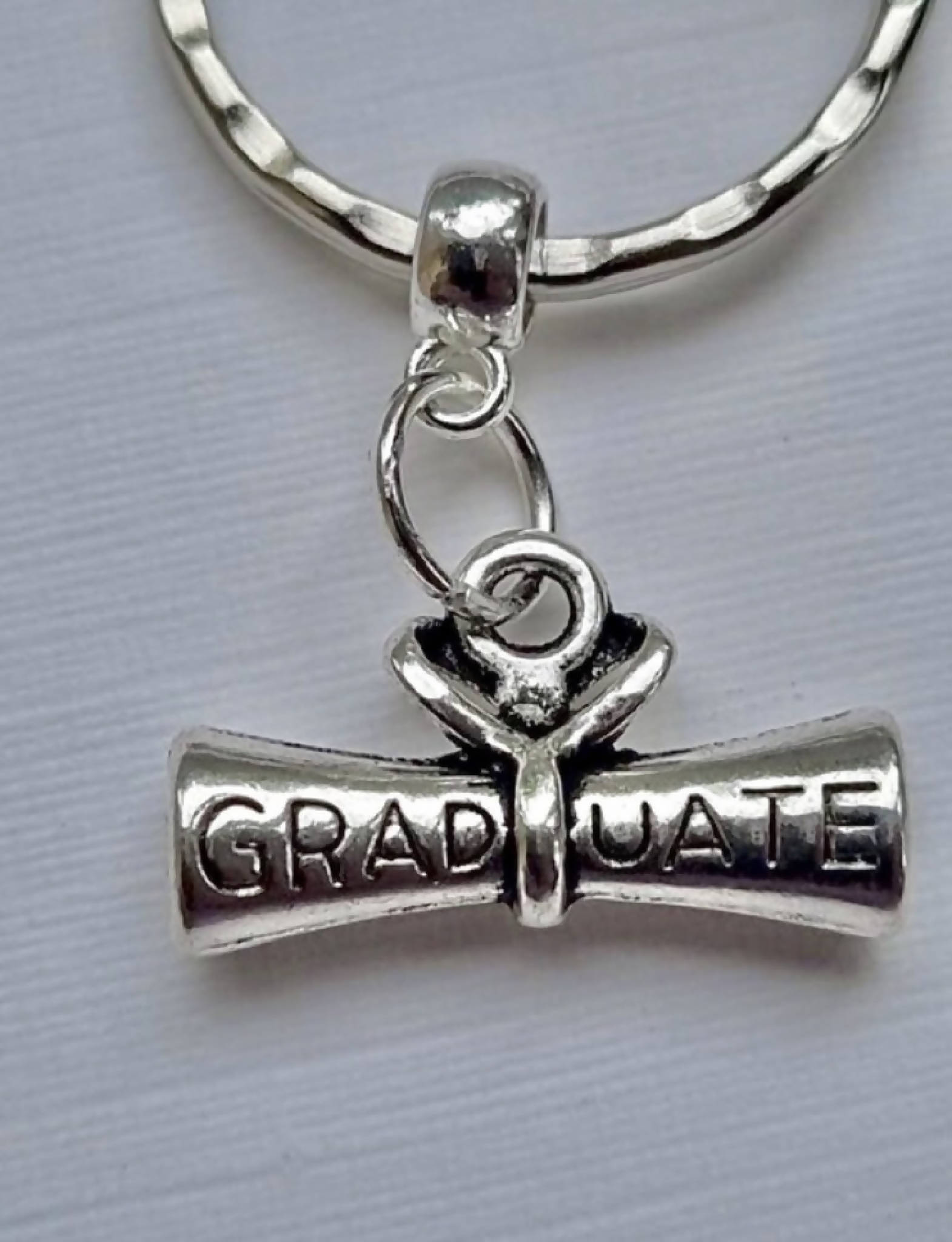 Graduation gift keyring with 3 charms; a scroll, a lucky horseshoe and two goblets, and the word ‘Cheers’. A super gift for a graduate.